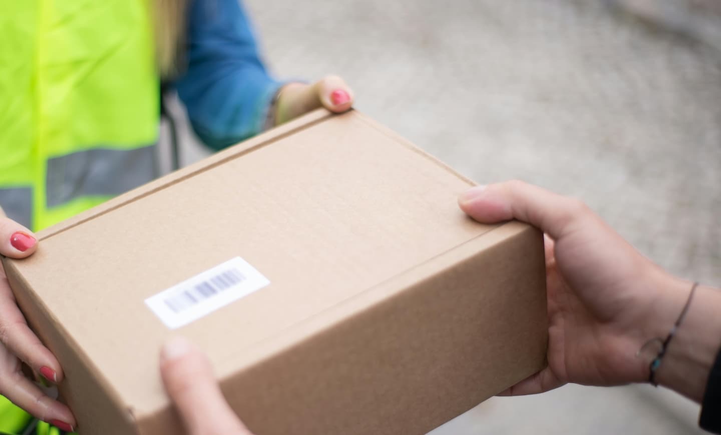 Ein Paket wird an eine Zustellperson übergeben